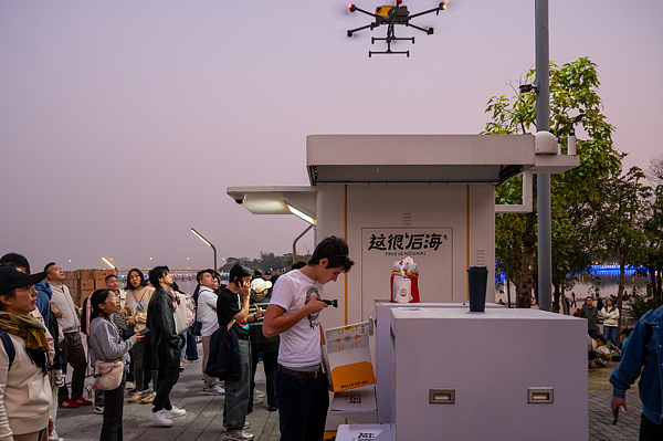 在深圳，外國游客體驗(yàn)無人機(jī)外賣送餐。